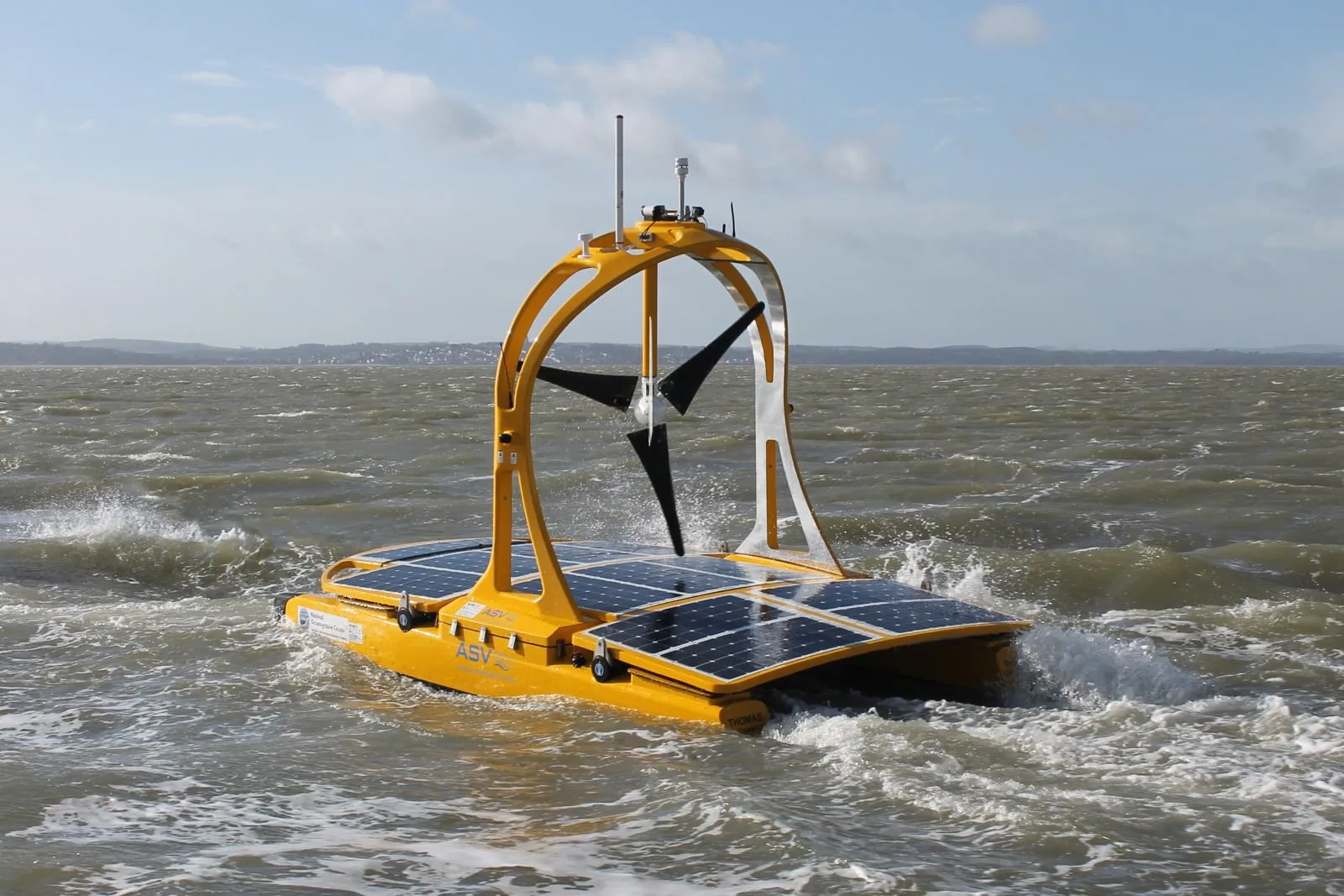 Photo of a small catamaran with a wind turbine