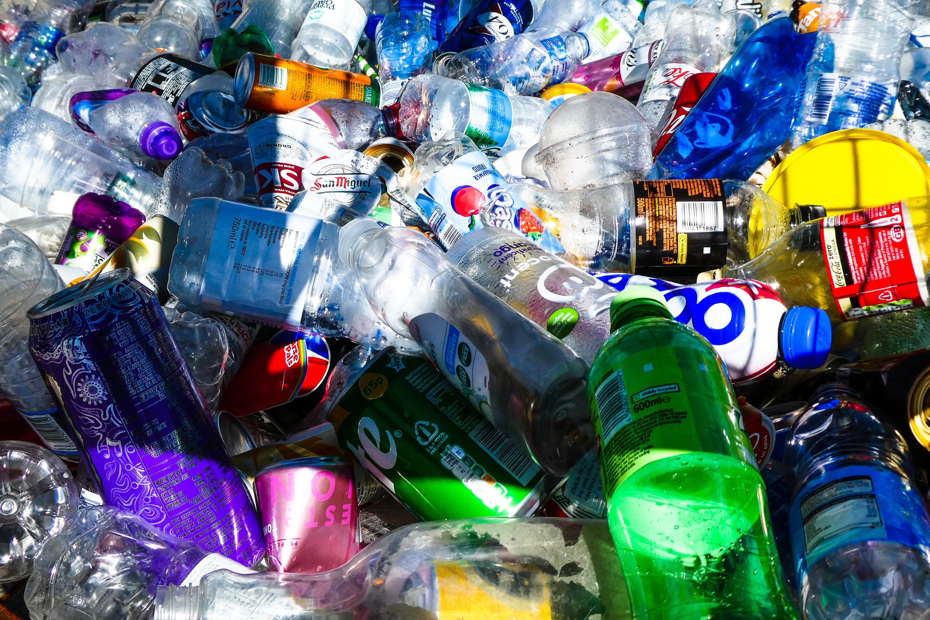 A jumbled assortment of recyclable cans and plastic in a pile